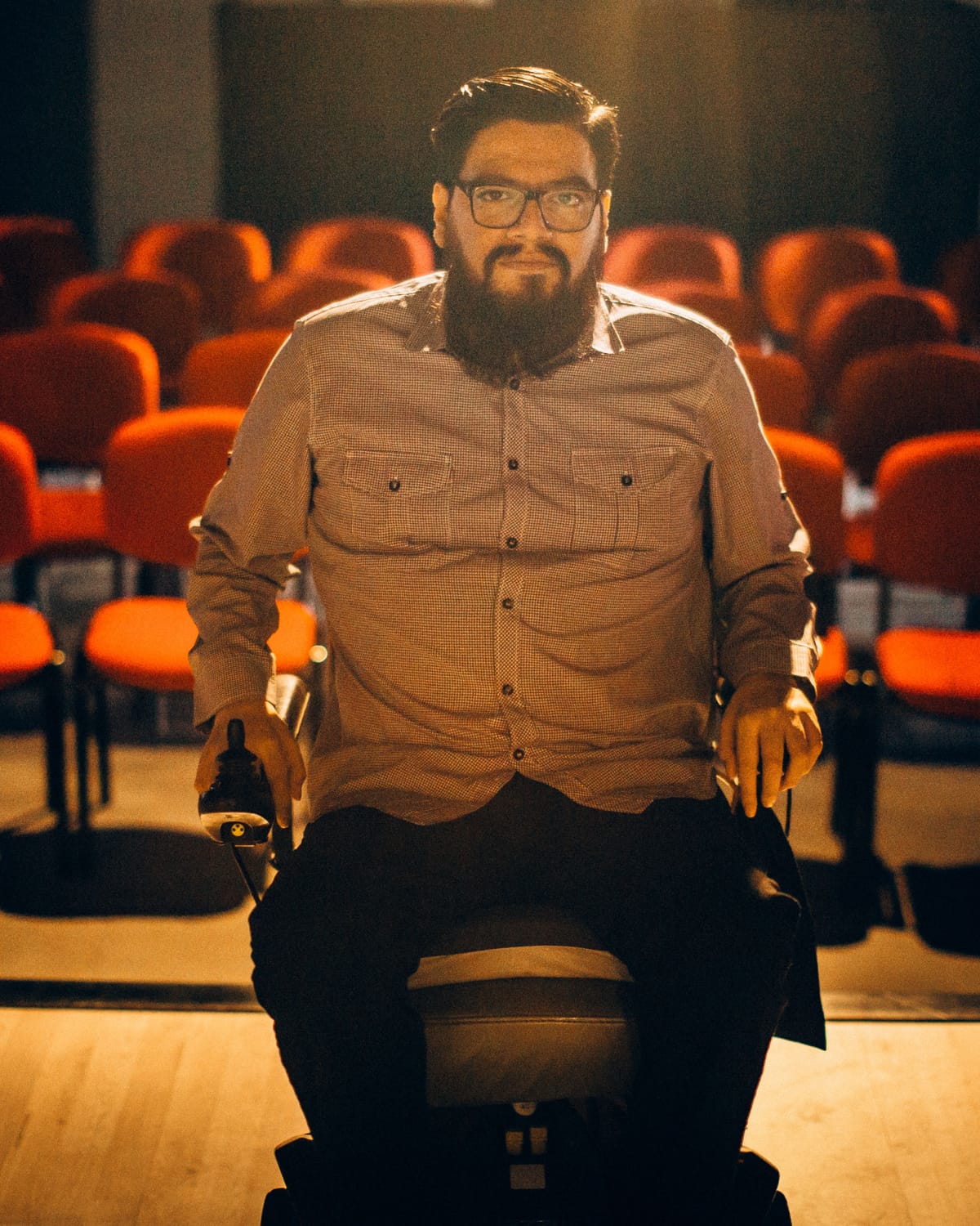 Retrato del pastor Abraham Lucero sentado en el auditorio