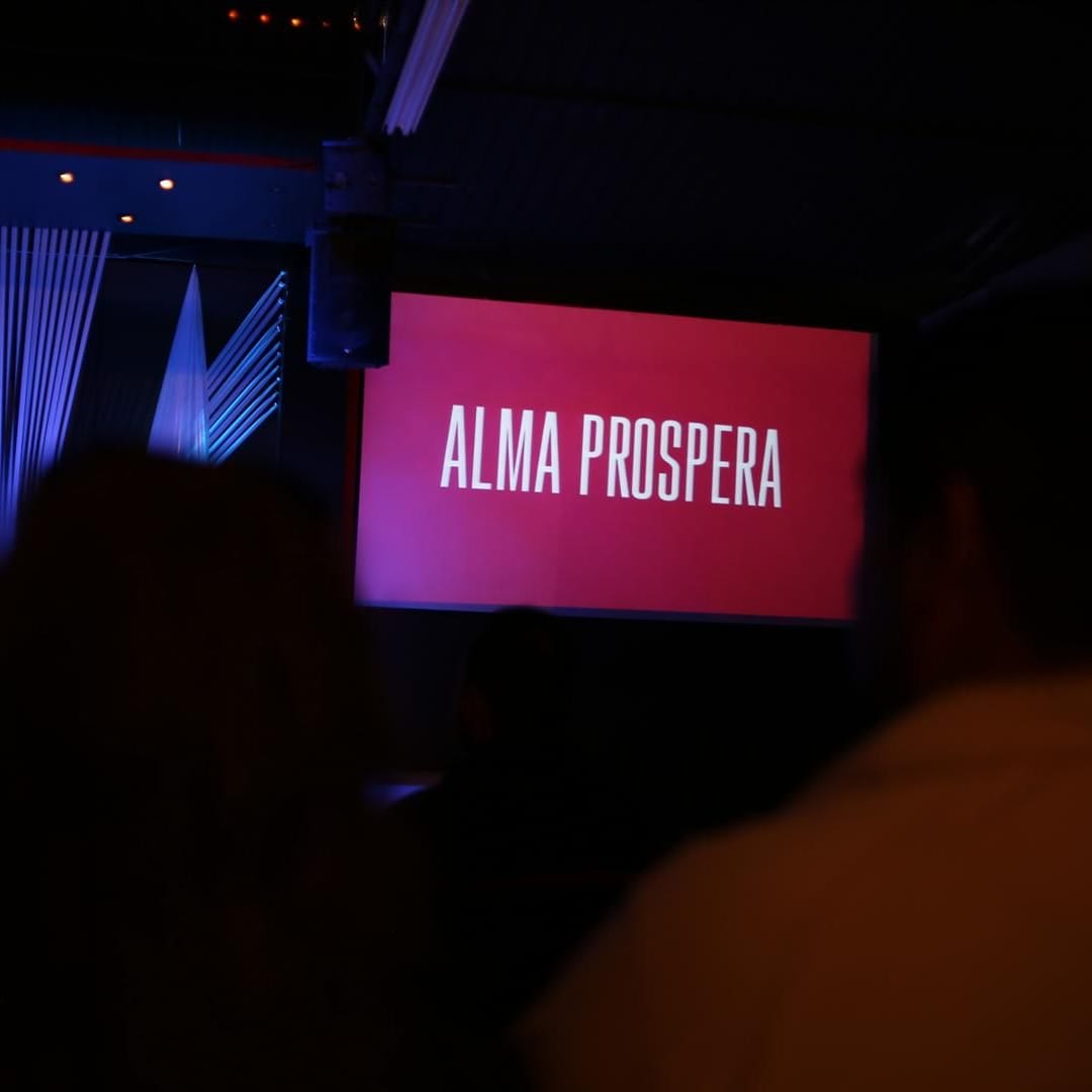 Pantalla del auditorio con el título de la serie Alma Próspera